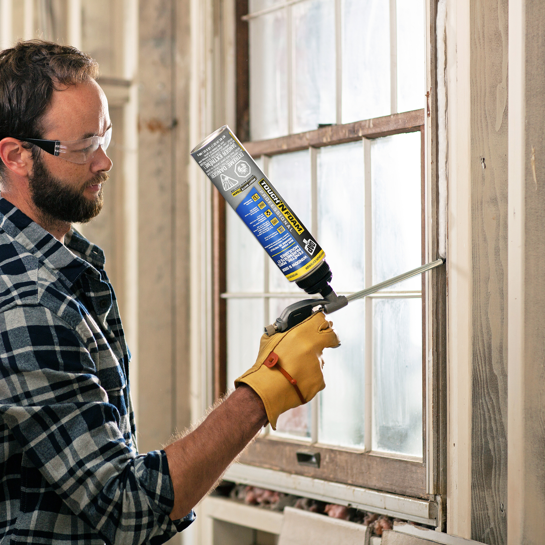 Man sealing window using touch n foam professional gun foam